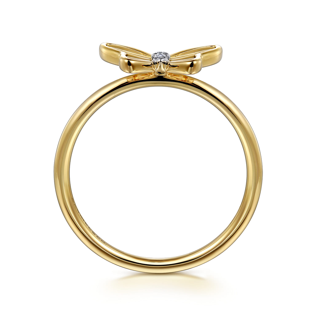 Gold ring with bow design and diamond on a white background
