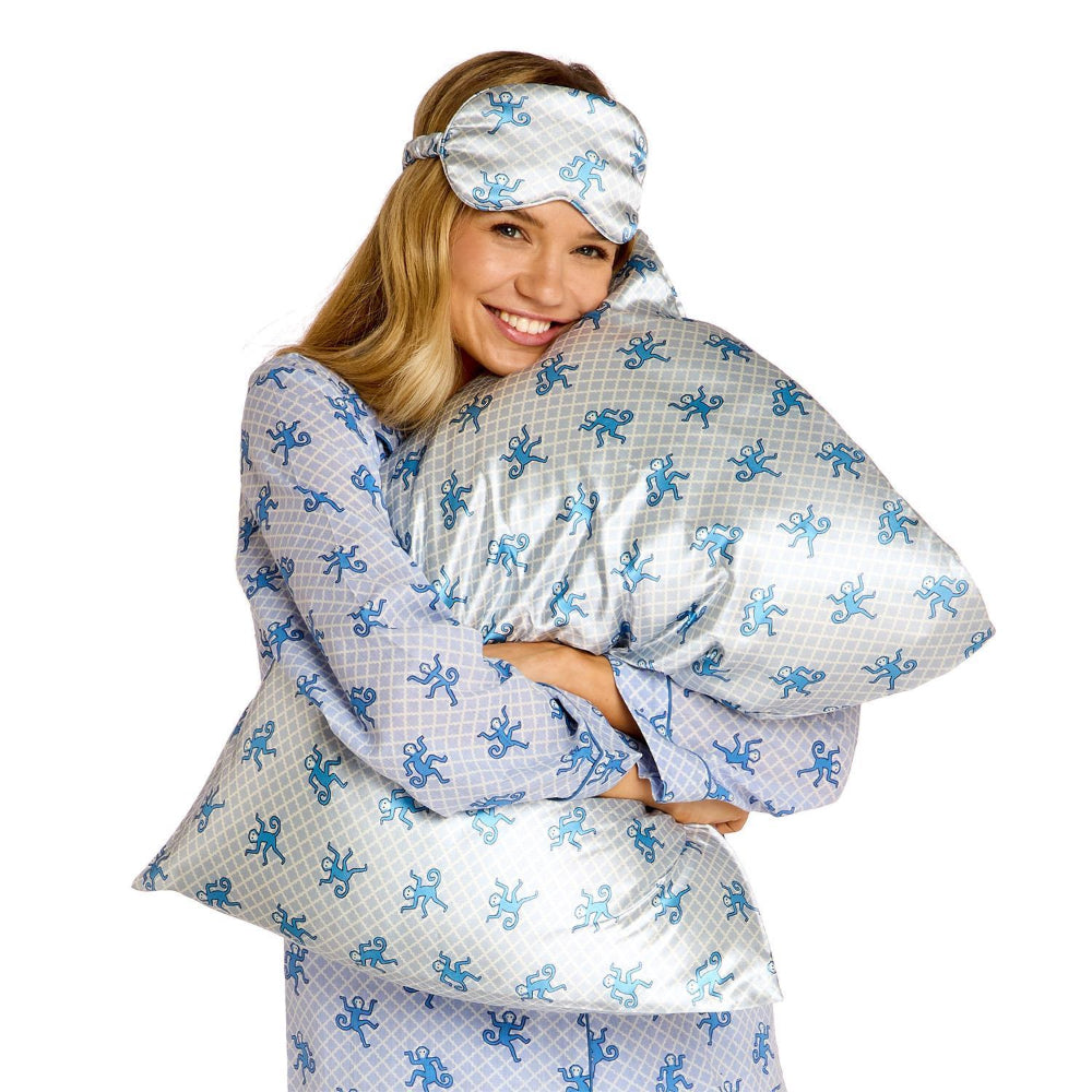 Woman wearing a matching pajama set with blue monkey pattern on a white background