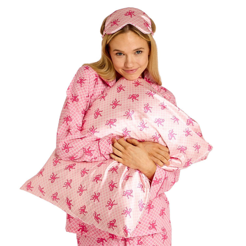 Person wearing a pink robe with butterfly pattern and matching headband on a white background