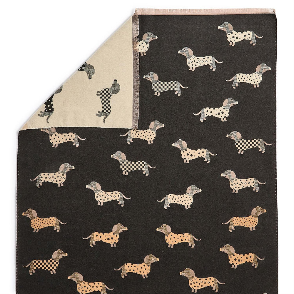 A close up photo of a reversible black & beige scarf with differant shades of  beige dachshund dog patterns on a white background.