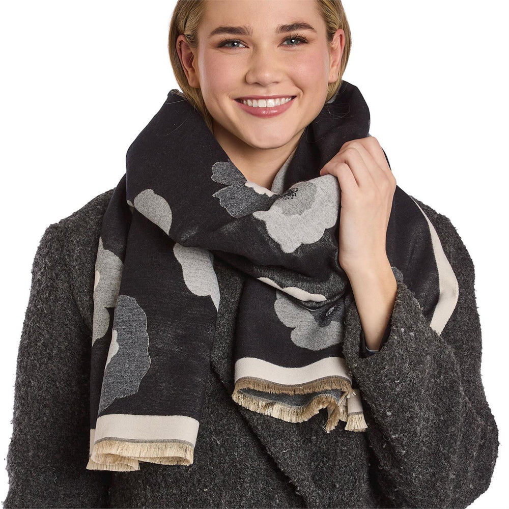 Woman wearing a dark gray mulit floral patterned scarf on a white background.