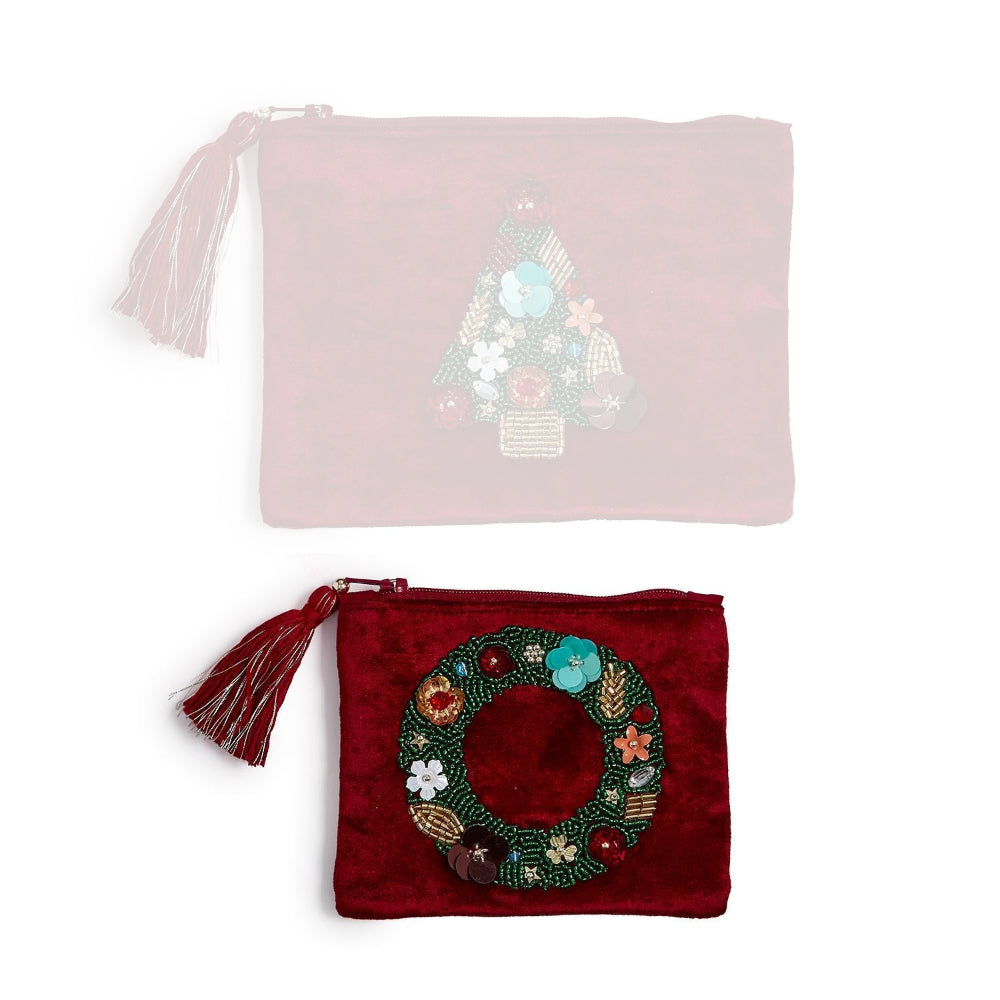 A burgundy pouch with a holiday wreath design and tassel on a white backround. 