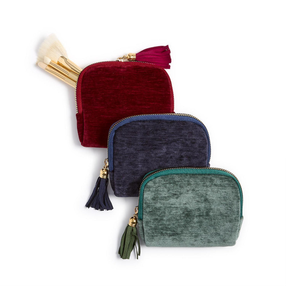 Three small velvet pouches in red, blue, and green with tassels on a white background.