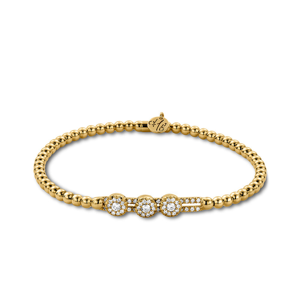 Gold bracelet with three diamond-like stones on a white background