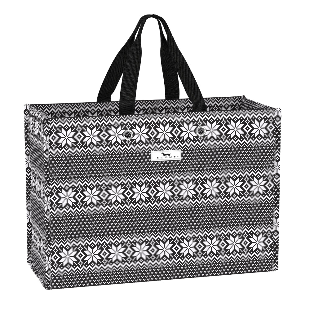 A rectangular gift bag with black handles, featuring a black and white Fair Isle knit-style pattern with snowflake and geometric motifs, and a small white brand label on the front.