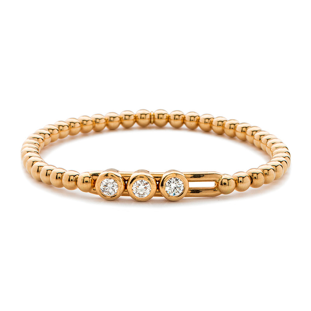 Gold bracelet with three diamonds on a white background