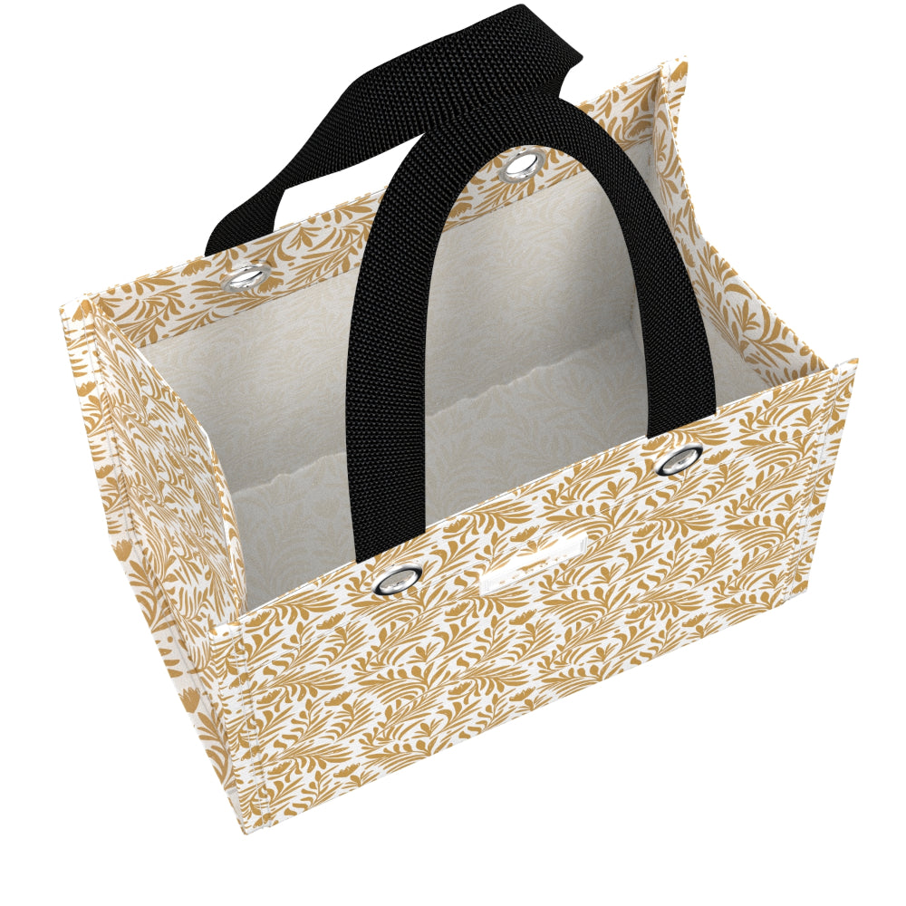 A rectangular gift bag with a beige and white leaf pattern exterior, a black webbed handle, and silver metal grommets, shown on a plain white background.