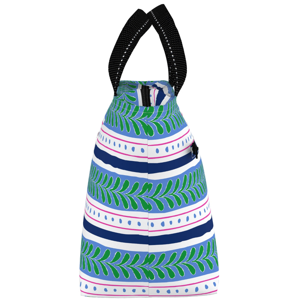 A small lunch bag with a colorful horizontal pattern of green leaves, navy blue stripes, and pink dotted lines on a white background, featuring black shoulder straps with white stitching.