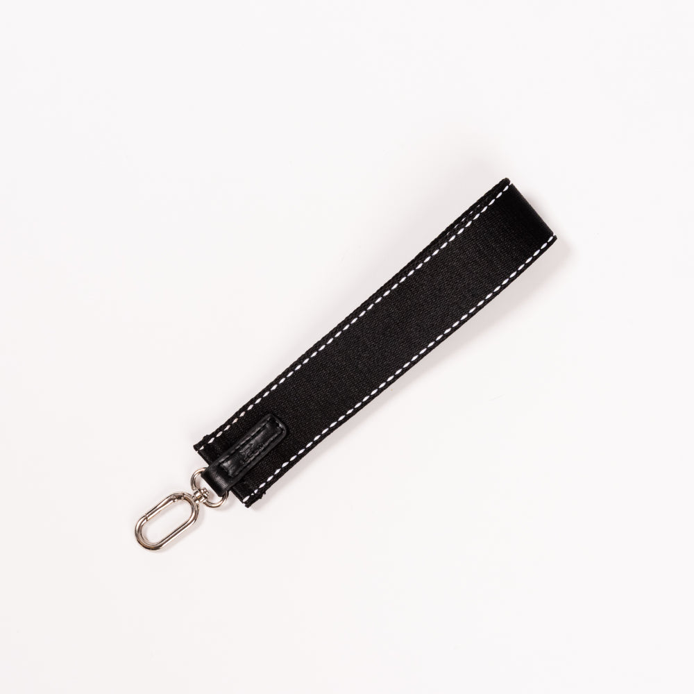 Black wristlet strap with silver clasp on a white background