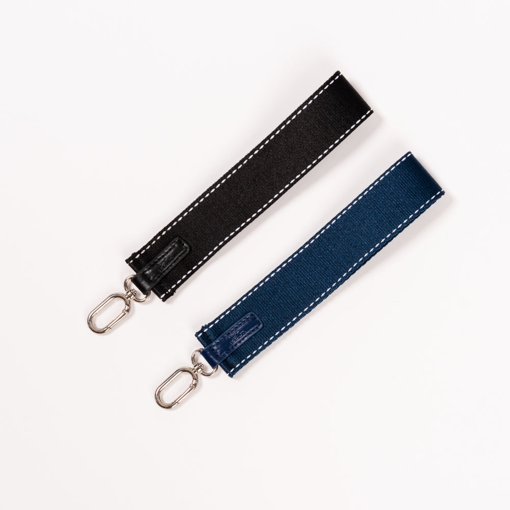 Black and blue fabric straps with metal hooks on a white background