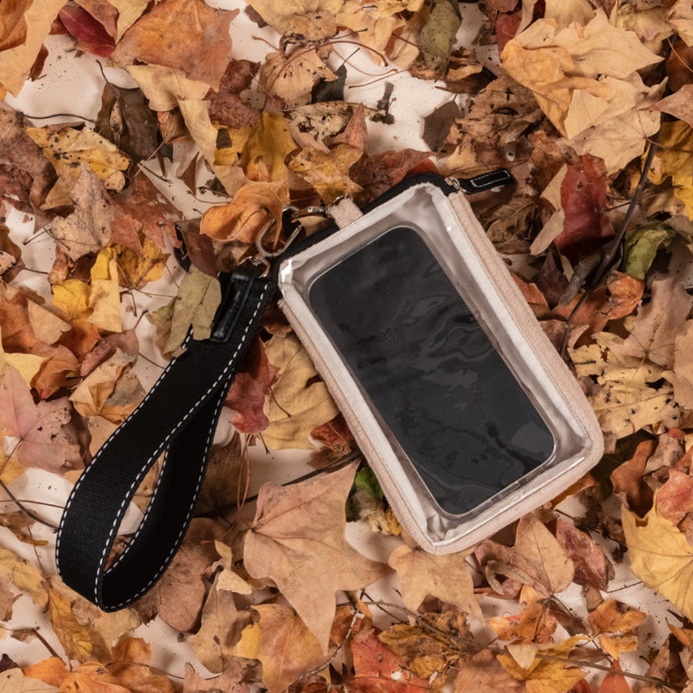 Phone case with strap on a bed of autumn leaves