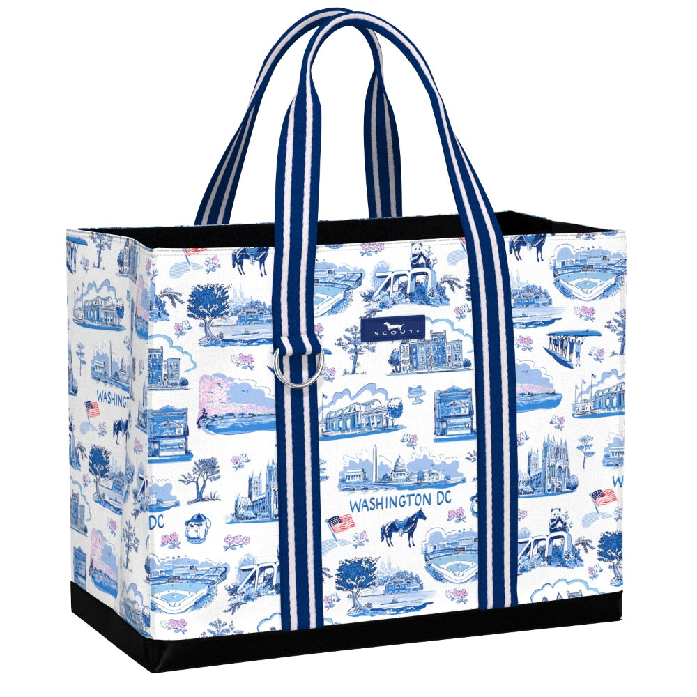 A tote bag with a white background and a blue illustrated toile-style pattern featuring Washington DC landmarks, with dark blue and white striped handles and black trim.