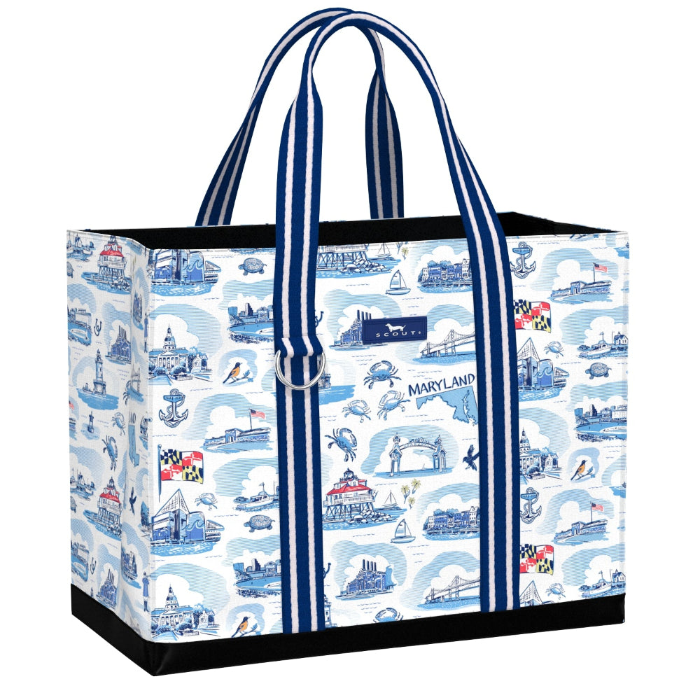 A large tote bag featuring a blue and white Maryland-themed toile-style print with illustrations of landmarks, boats, crabs, and the Maryland state flag. The bag has thick blue and white striped handles and black trim at the base.
