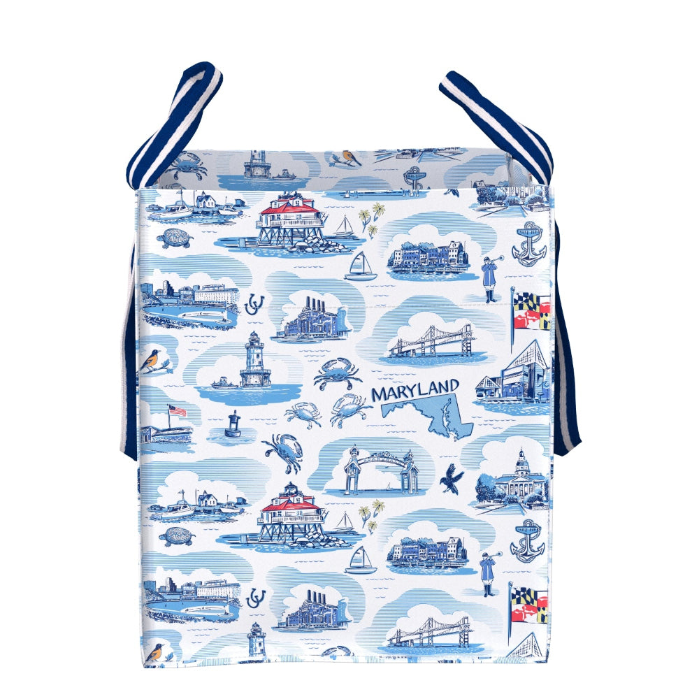 A square fabric bag or pouch with a blue and white Maryland-themed toile-style print, featuring illustrations of landmarks, boats, crabs, and the word 'Maryland.' It has dark blue striped ties at the top and is shown on a plain white background.