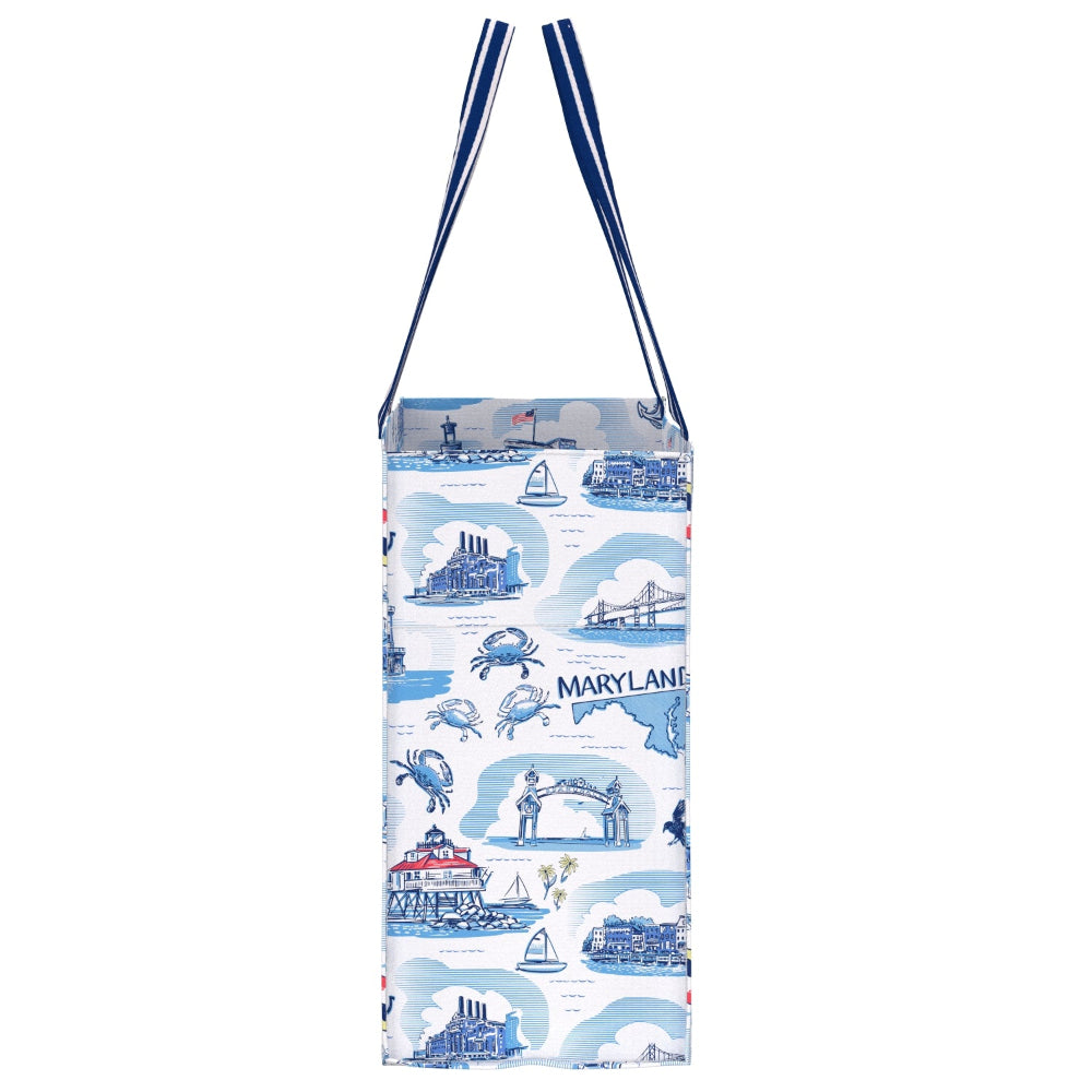 A tall tote bag with navy blue shoulder straps, featuring a white body printed with blue illustrations of Maryland landmarks, crabs, boats, and the word 'MARYLAND'.