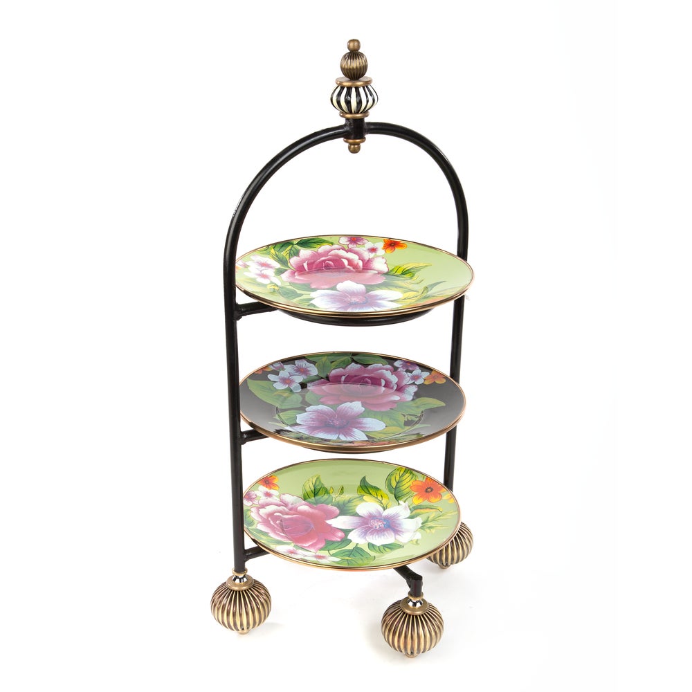 Three-tiered decorative stand with floral plates on a white background