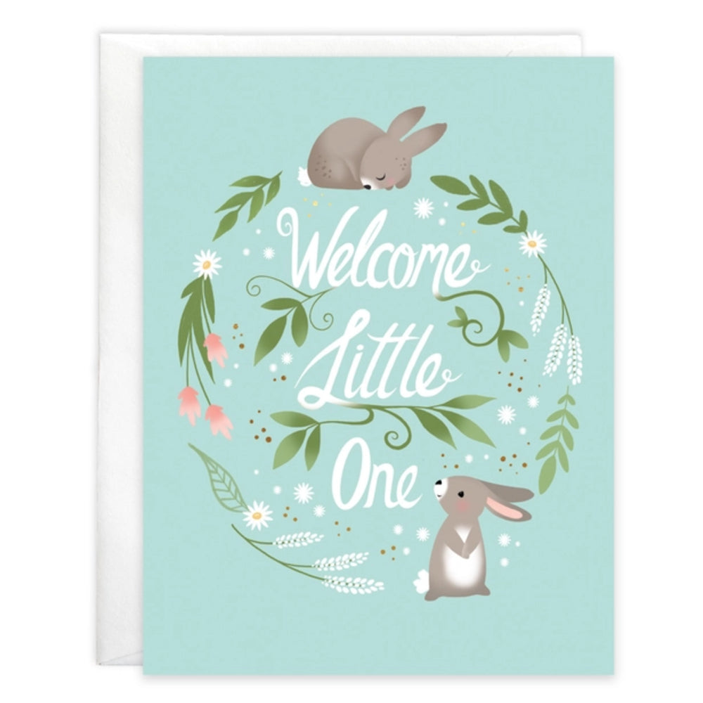 Greeting card with rabbits and floral wreath on a light blue background