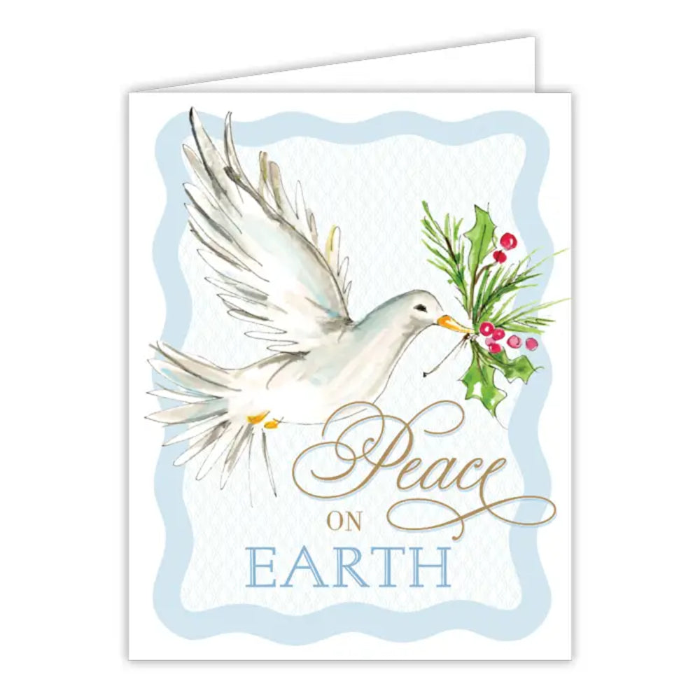 A greeting card featuring a watercolor-style dove holding green holly with red berries, with the words 'Peace on Earth' in gold and blue lettering. The card is shown slightly open against a plain white background.