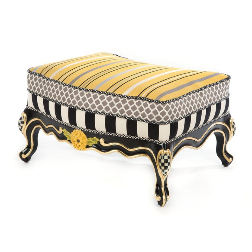Decorative ottoman with striped pattern and ornate legs on a white background