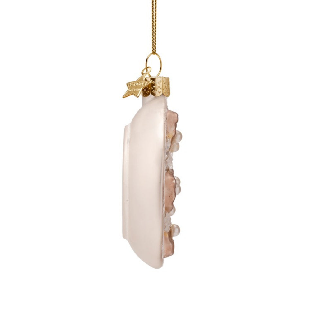 Decorative oyster plate glass ornament on its side on a white background. 