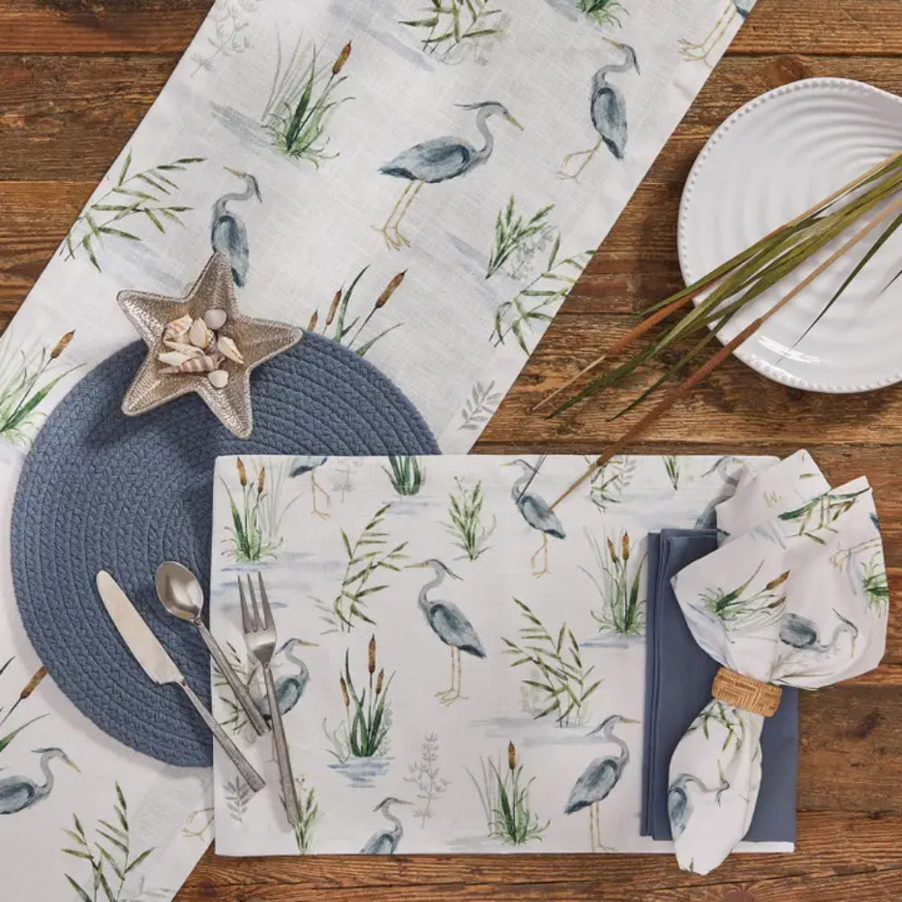 Homegoods pieces featuring Heron table runners & napkins on wooden table surface. 