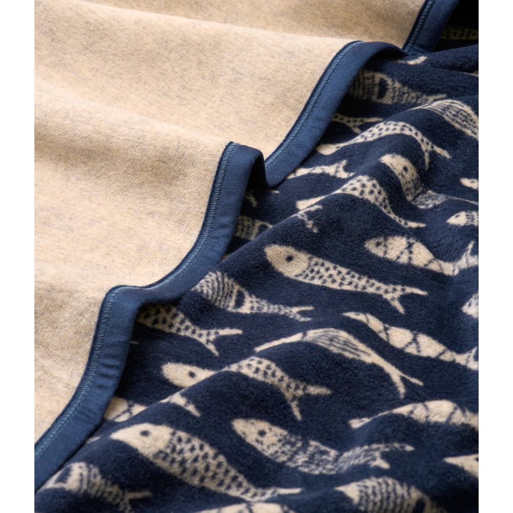Navy blanket with fish pattern on a beige background