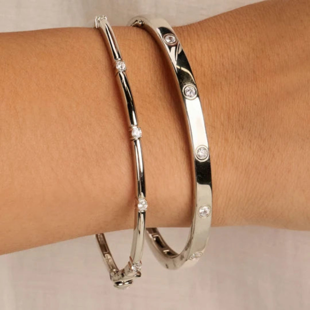 Two polished silver bangle bracelets with small clear rhinestone accents