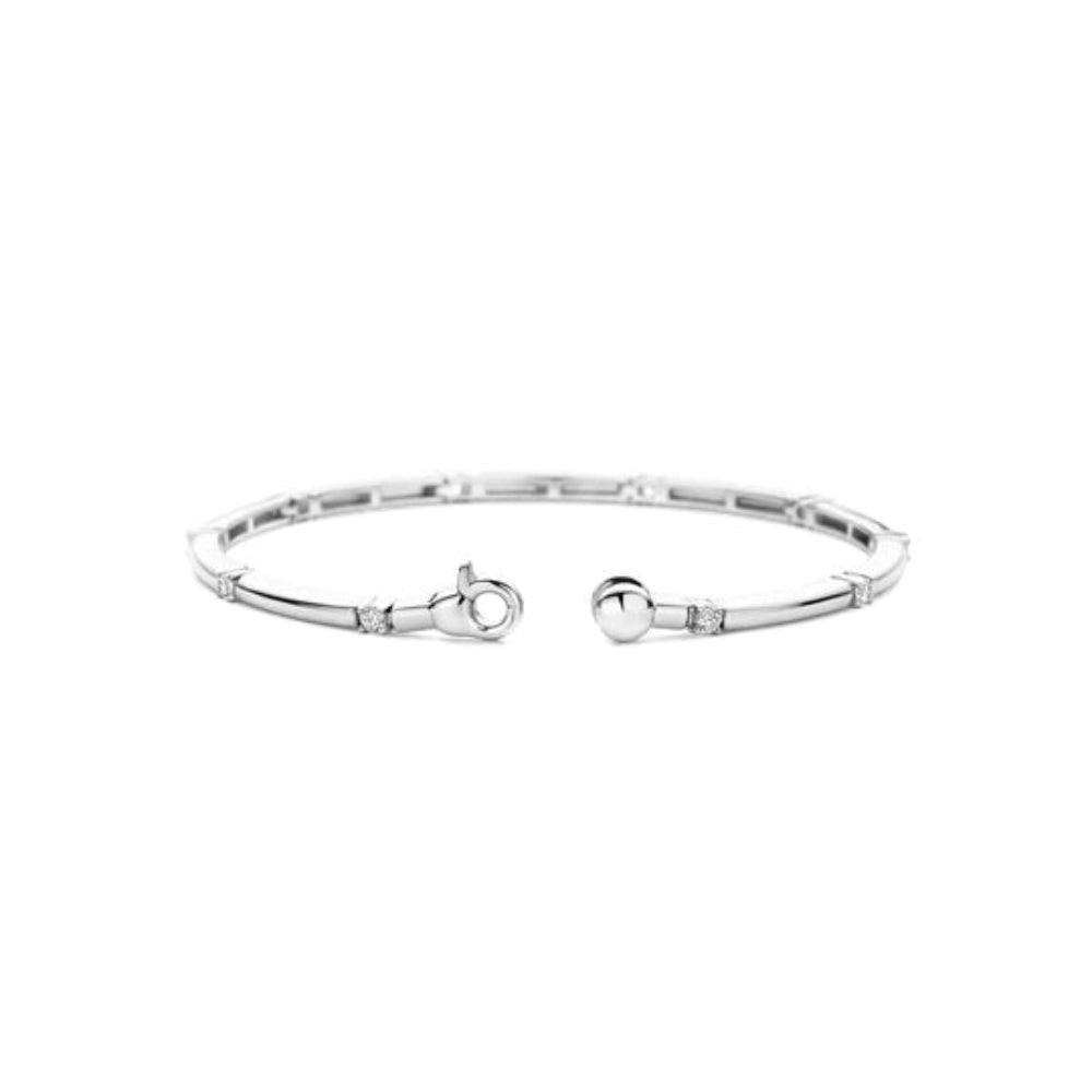 A silver bangle  bracelet with a polished finish, featuring a clasp 