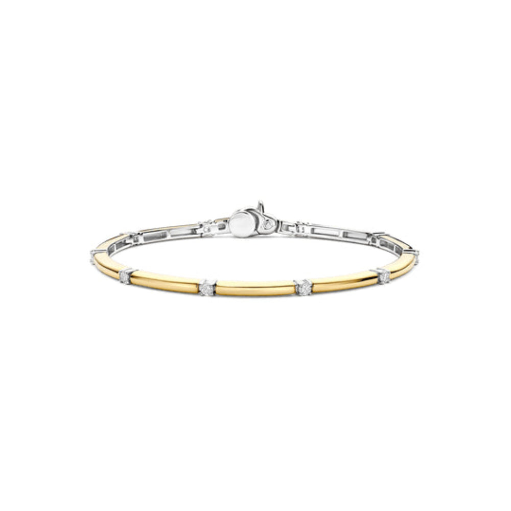 A two-tone bangle bracelet featuring a polished yellow gold center band flanked by a silver-toned outer band, accented with small round clear stones at intervals.
