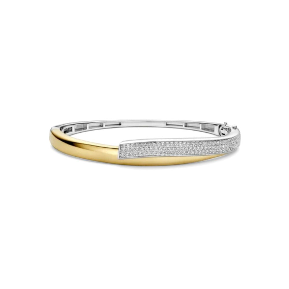 A two-tone silver and gold bangle bracelet with a pavé diamond accent and a twist 
