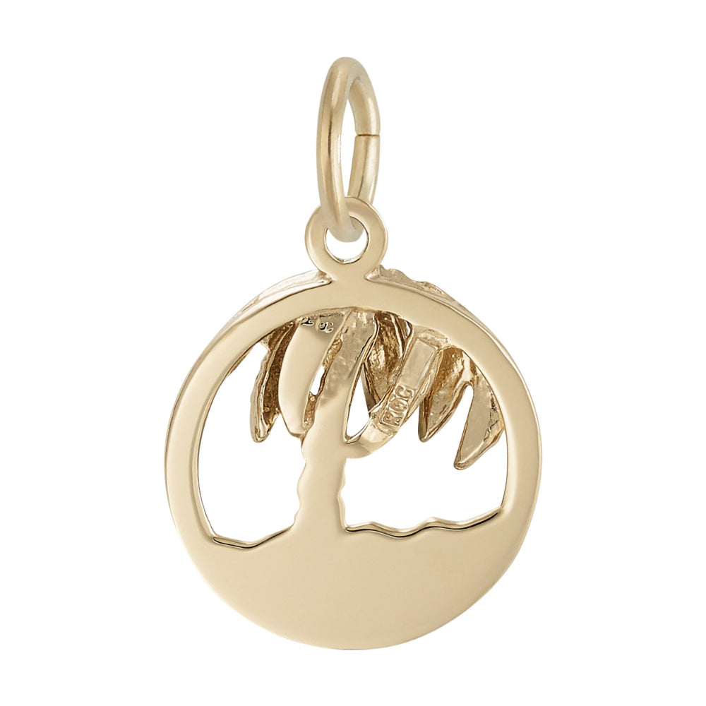 Reverse side of a Round gold charm with cutouts ion the middle to from a palm tree and beach, on a white background