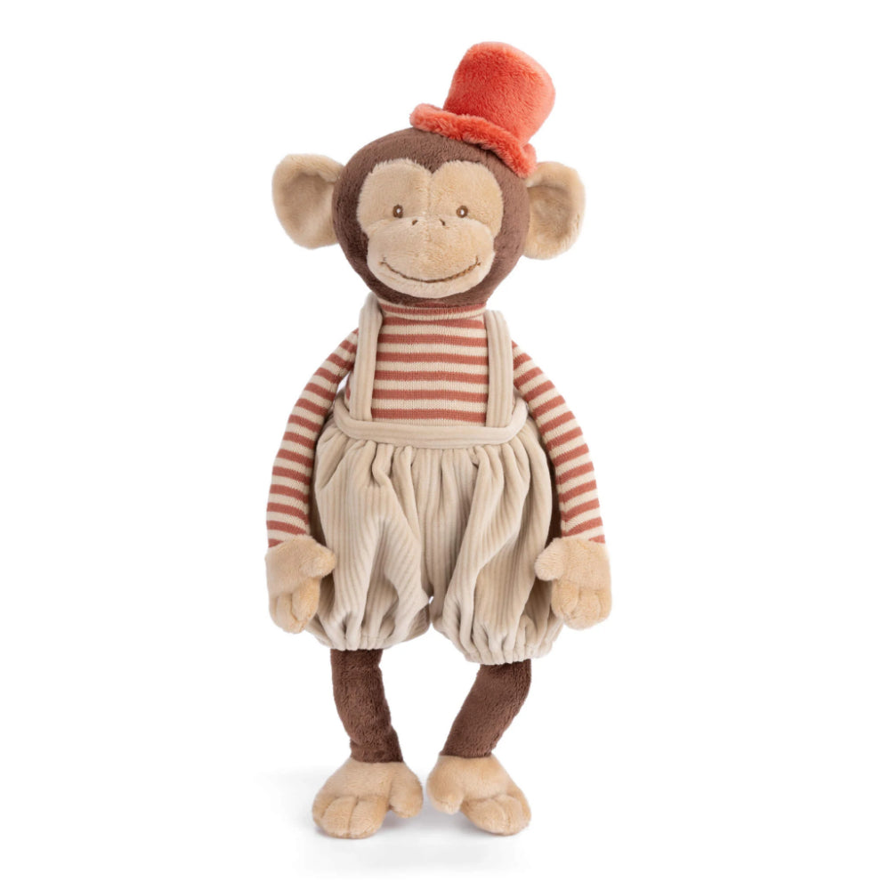 A tan stuffed monkey toy with a red hat and striped shirt and tan corduroy overalls on a white background. 