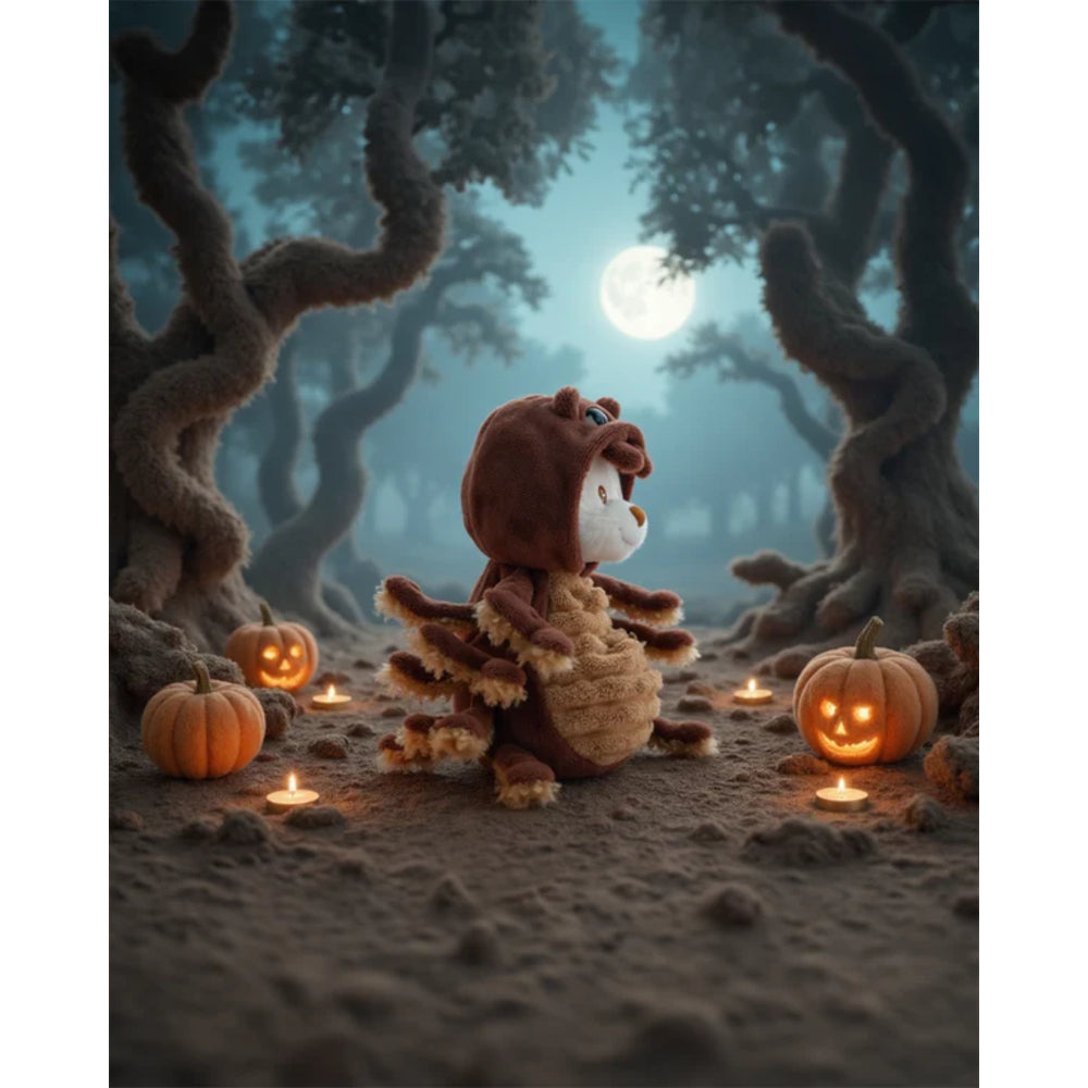 White teddy bear with a brown spider outfit on in a mystical forest with pumpkins and candles under a full moon.