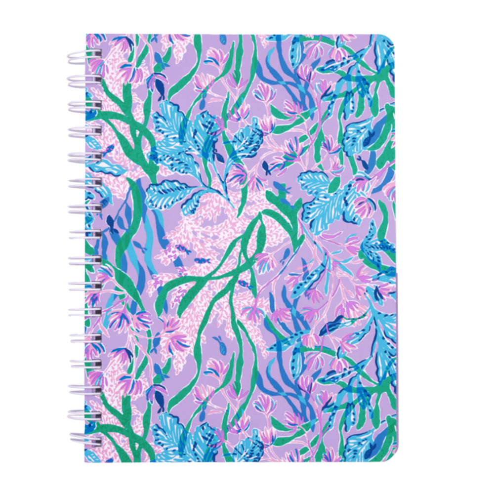A spiral-bound notebook with a colorful floral and leaf pattern on a light purple cover, shown against a plain white background.