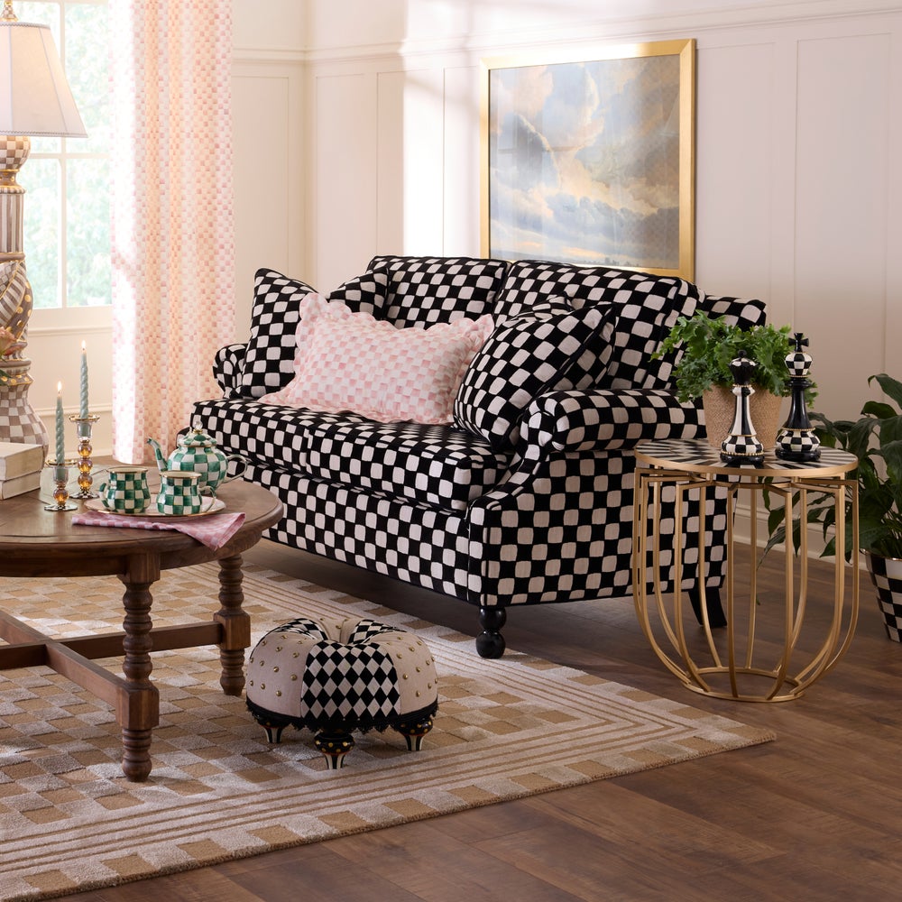 Living room with black and white checkered sofa, wooden coffee table, and decorative elements.