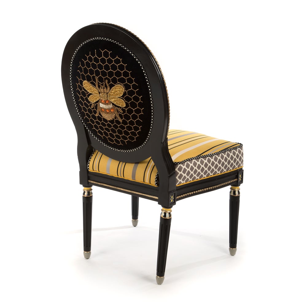 Decorative chair with bee and honeycomb design on a white background