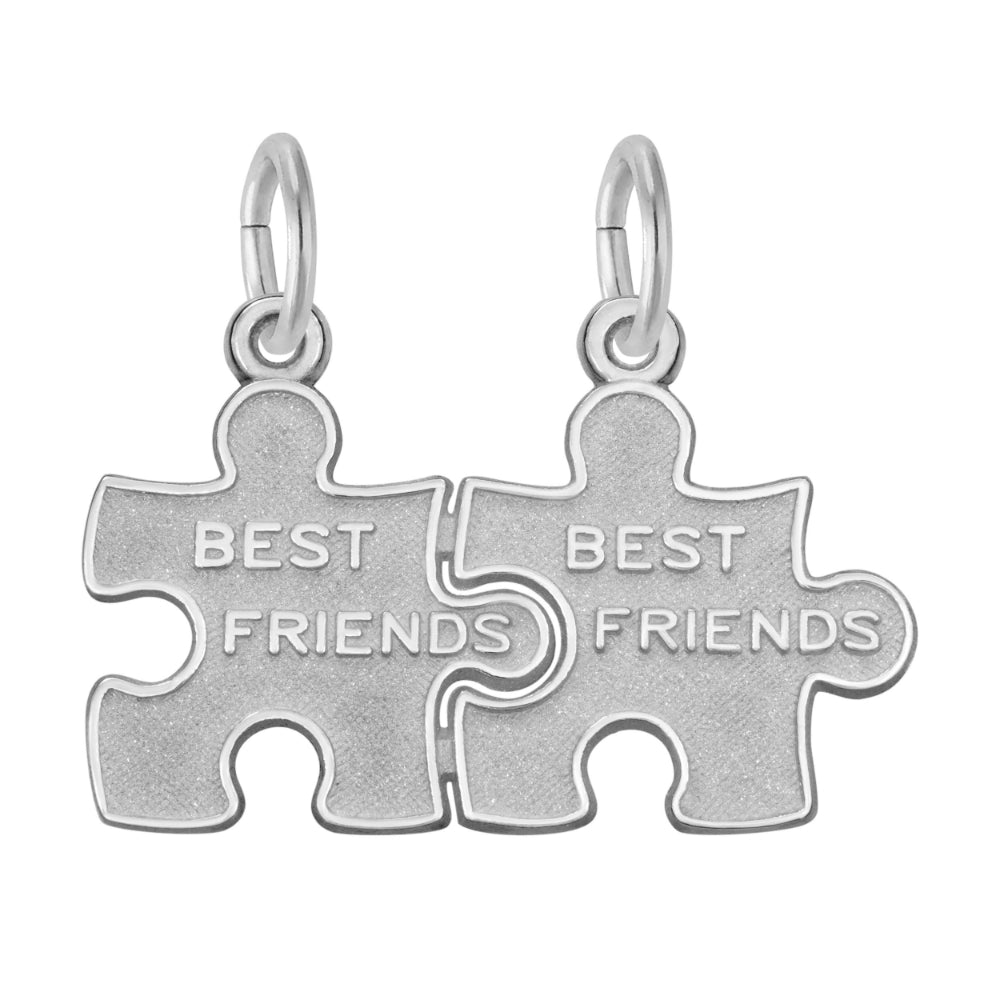 Silver break apart puzzle piece charm with 'BEST FRIENDS' engraved on them on a white background