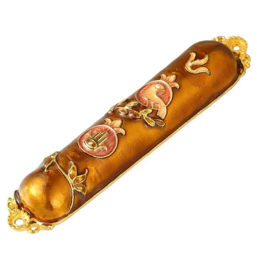 A gold-colored mezuzah with floral patterns and crystal accents on white background
