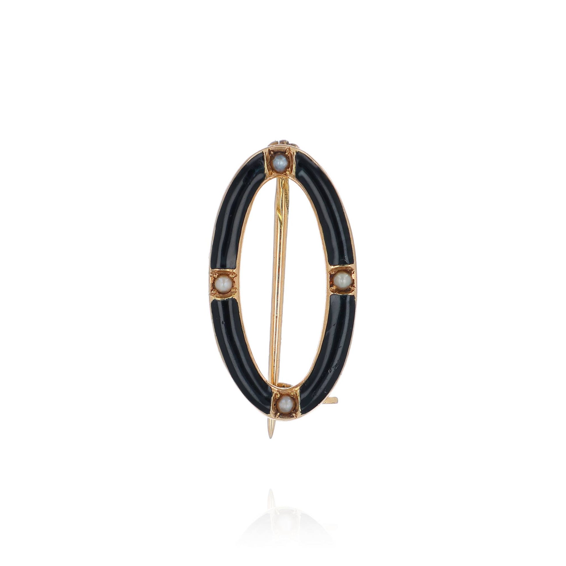A yellow gold and black enamel open oval seed pearl pin on a white background