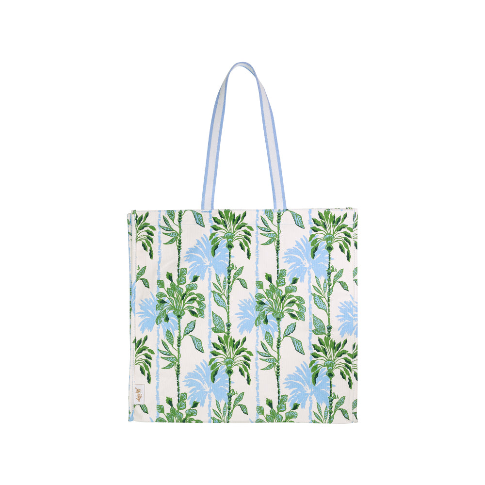 A white canvas tote bag with a vertical striped pattern featuring green leaves and light blue flowers, complete with two light blue shoulder straps, shown against a plain white background.