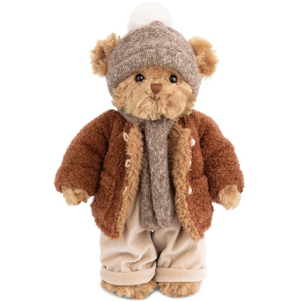 Stuffed teddy bear wearing a brown coat, scarf, and hat on a white background