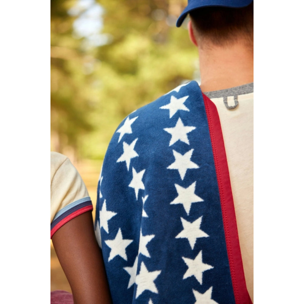 Person wearing a blue blanket with white stars outdoors
