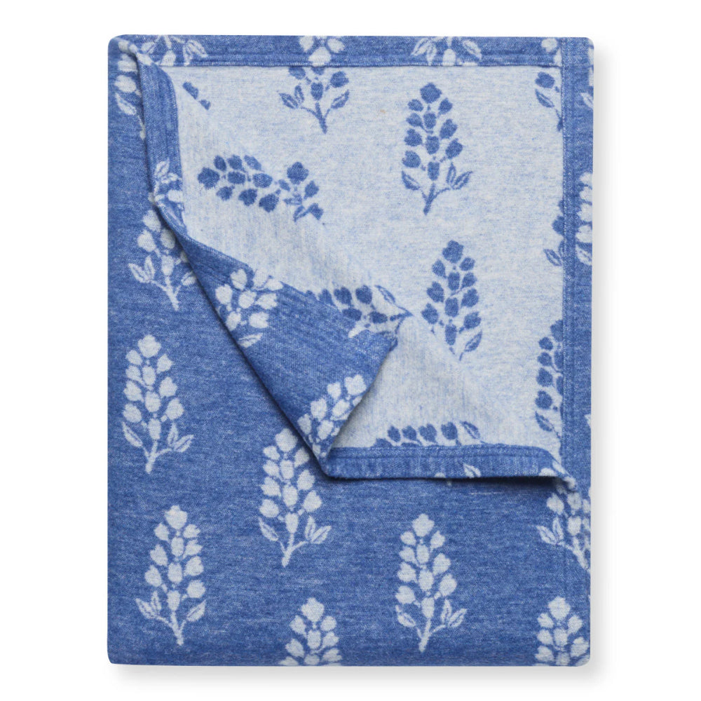A blue floral lightweight blanket on a white background. 