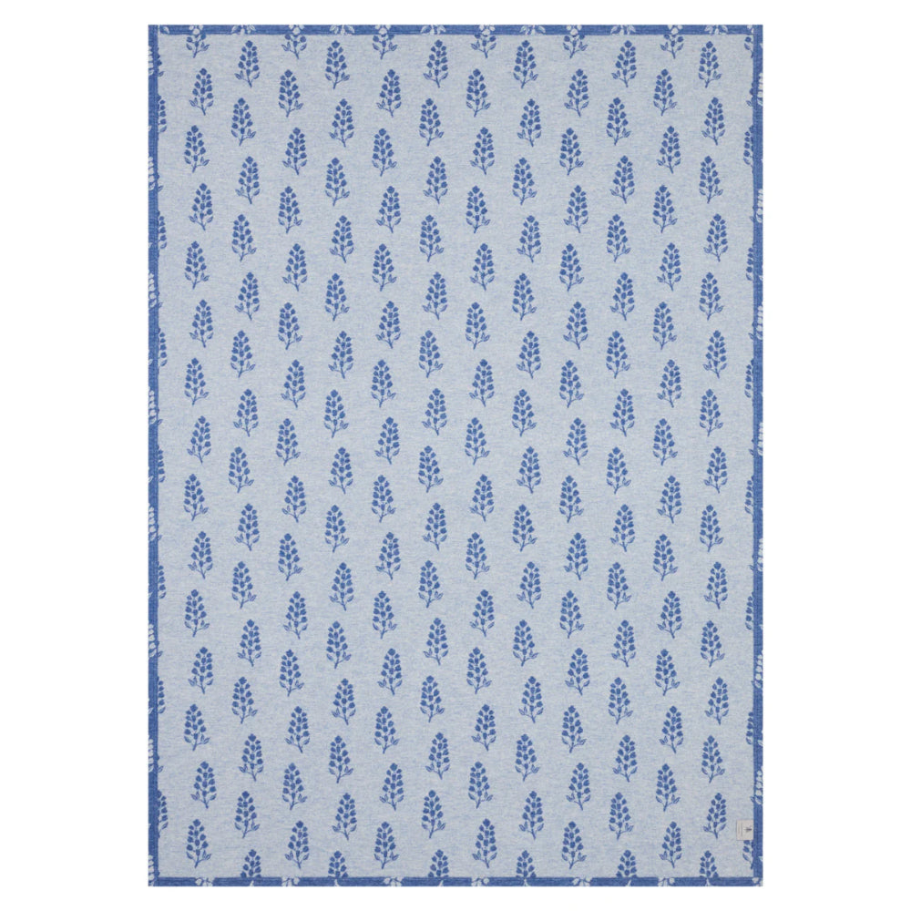 A blue lightweight blanket with floral patterns on a white background. 