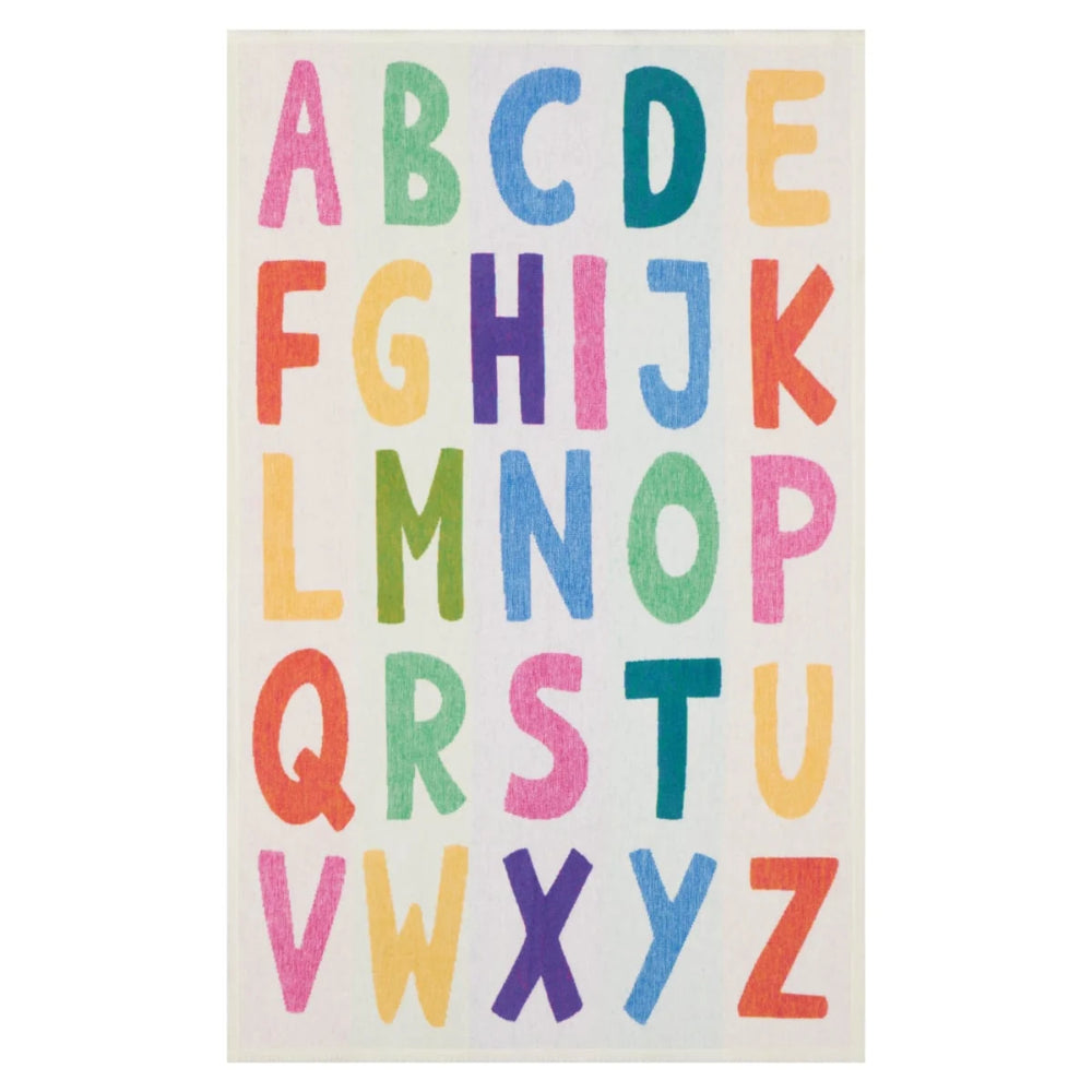 A rectangular rug featuring the alphabet in colorful block letters on an off-white background.