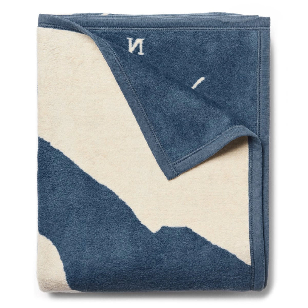 Blue and Beige blanket folded on top right corner on white background. 