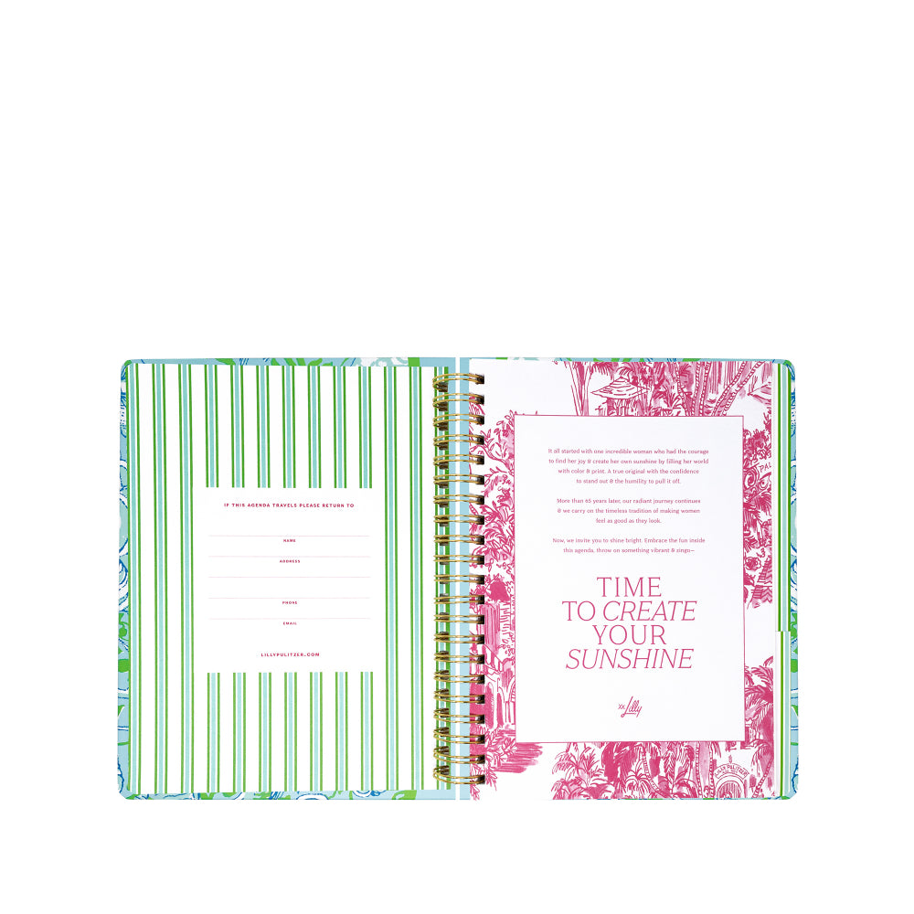 Open planner with green striped and floral design pages on a white background