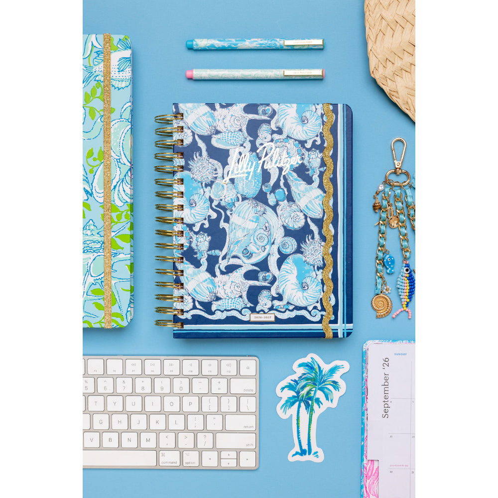 Notebook with decorative cover on a blue background with stationery items