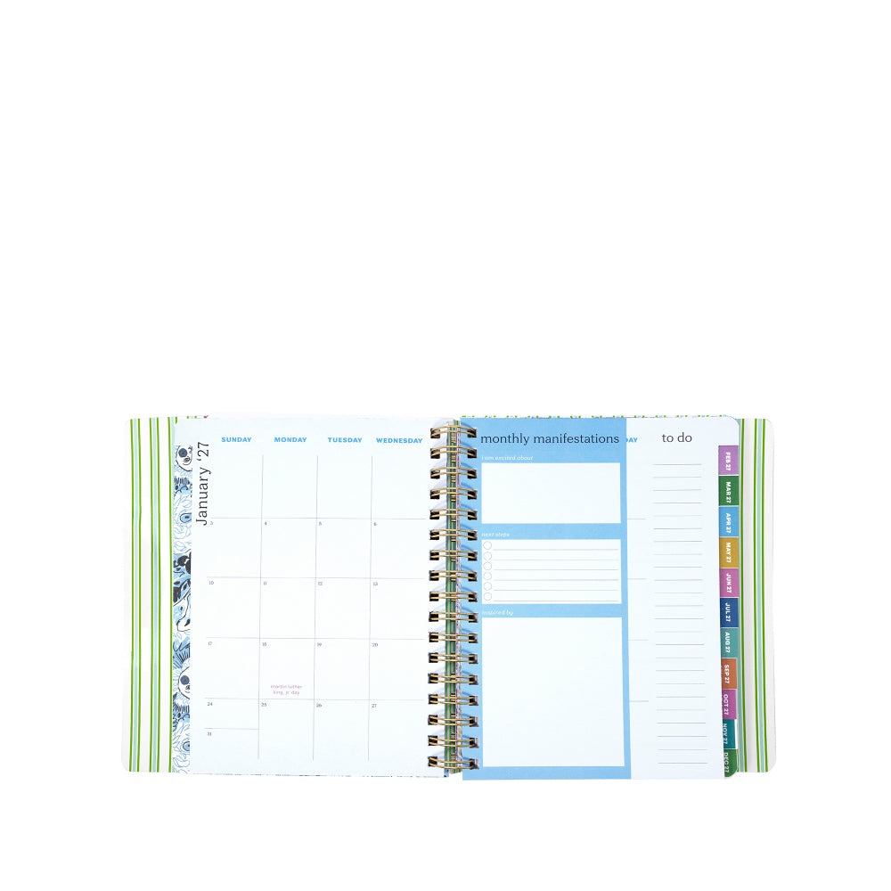 Open planner showing monthly layout with colorful tabs on a white background