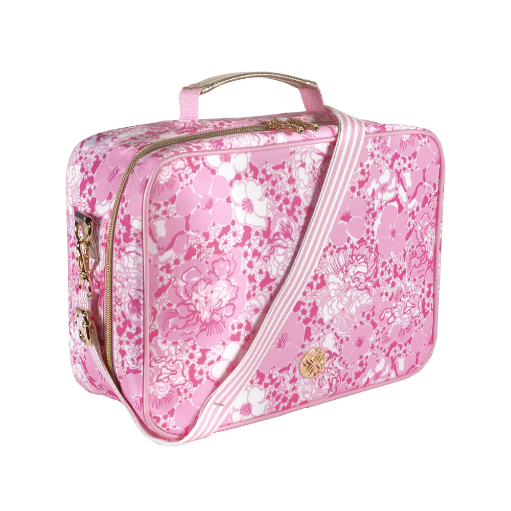 A angled side photo of a pink floral patterned lunch bag with a matching crossbody strap and handle on a white background.